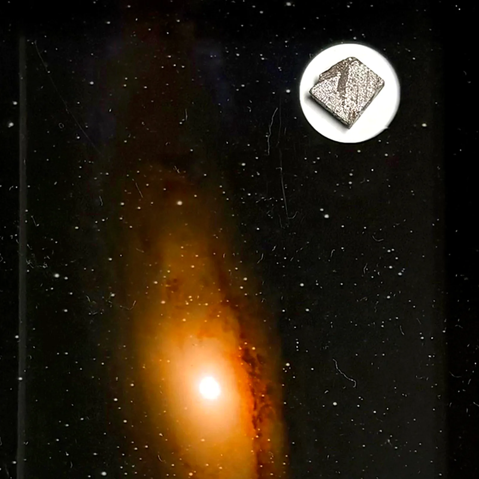 Tableau galaxie dorée avec météorite Aletai – cadre profondeur – gros plan sur la météorite