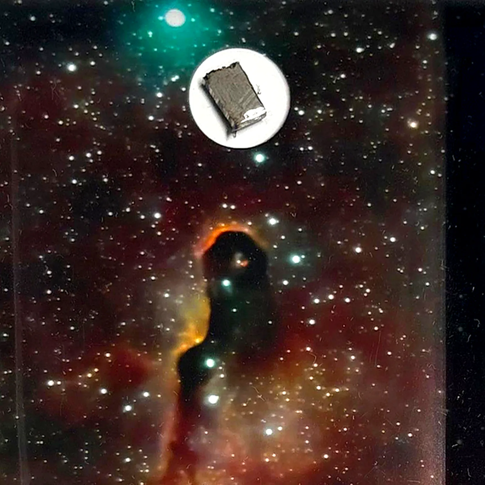 Tableau nébuleuse rouge avec météorite Muonionalusta – cadre profondeur – gros plan sur la météorite